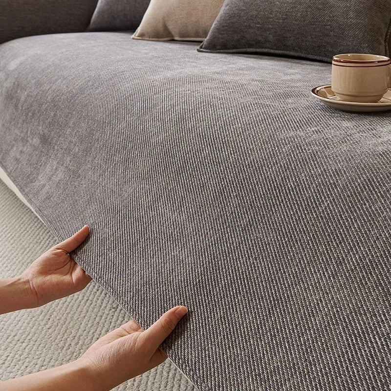 Chenille Sofa Cover in Stone — close-up of the ribbed chenille surface being smoothed by hand