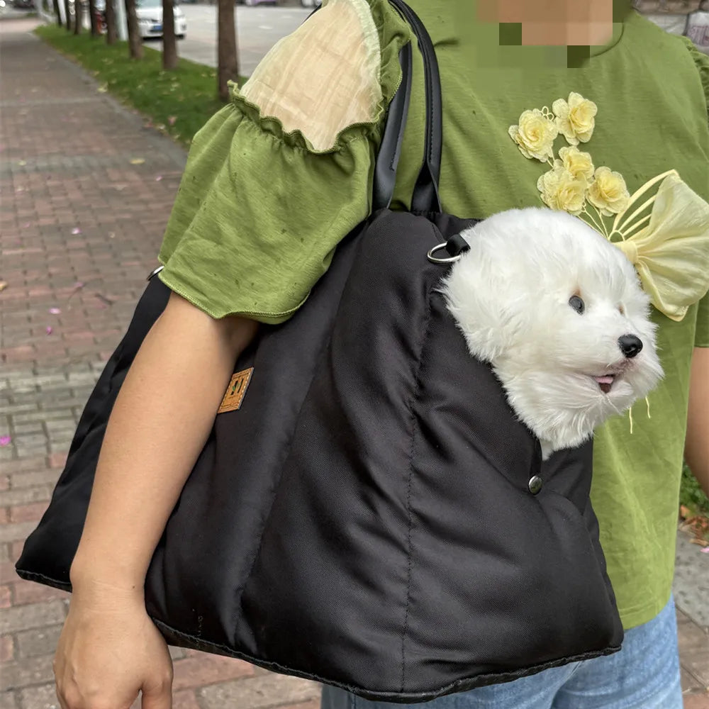 Soft-Sided Pet Carrier in Black — carried over the shoulder with a small dog