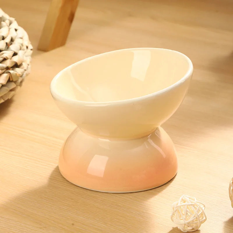Tilted Ceramic Cat Bowl in Sand — angled bowl on a wooden tabletop
