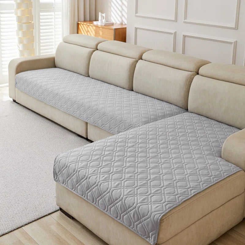 Quilted Sofa Protector in Mist — covering the seats of a cream sectional sofa