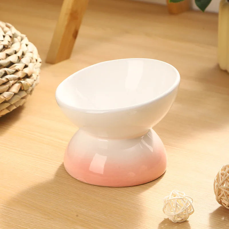 Tilted Ceramic Cat Bowl in Cream Blush — angled bowl on a wooden tabletop