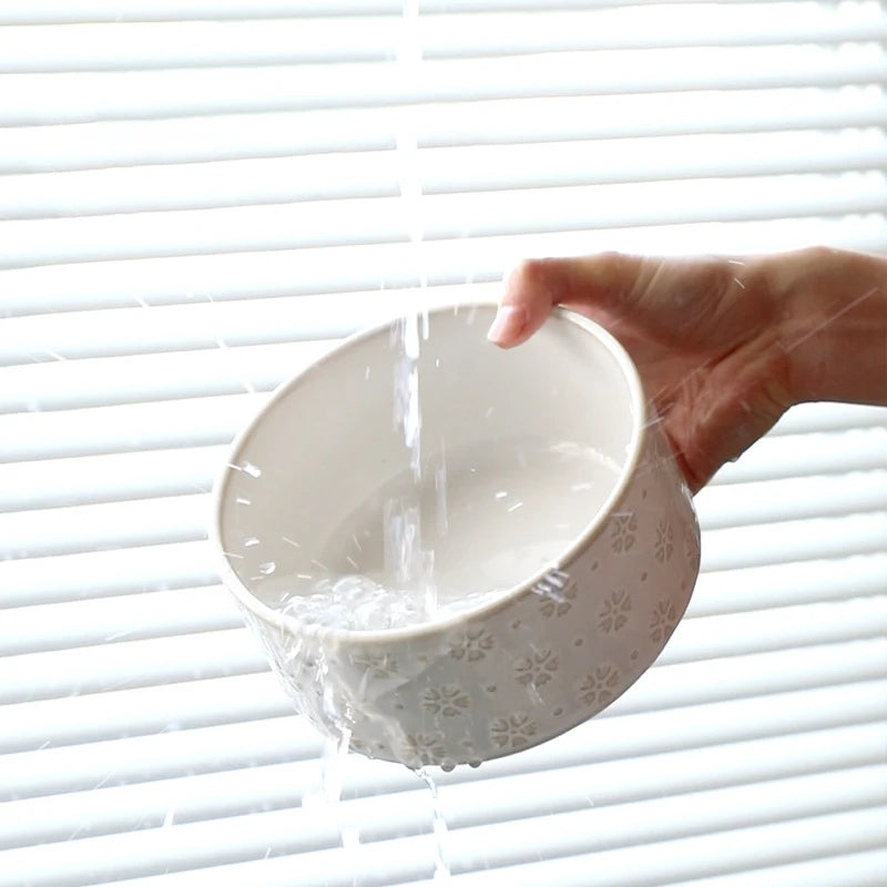 Raised Ceramic Feeder in Cream — ceramic bowl rinsed under running water