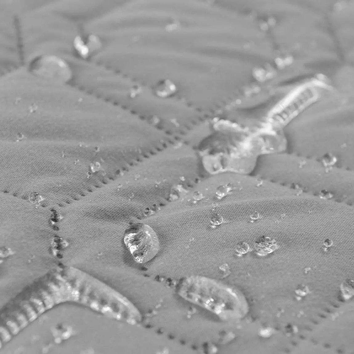 Quilted Sofa Protector in Mist — close-up of water beading on the quilted surface