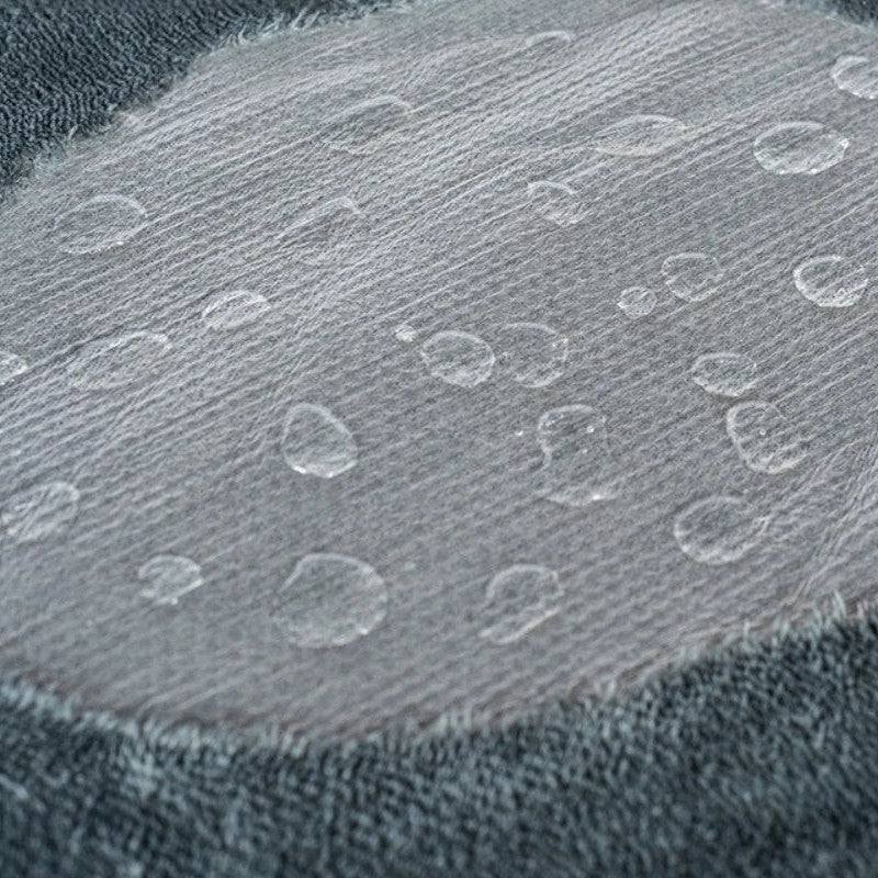 Reversible Sherpa Throw in Stone — close-up of water beading on the waterproof inner layer